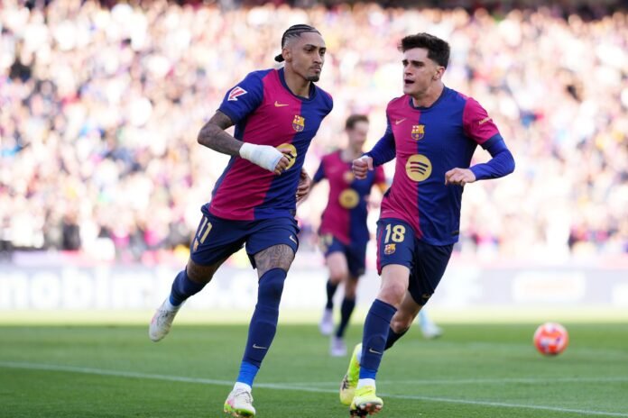 BARCELONA, SPAIN - APRIL 19: Raphinha of FC Barcelona celebrates scoring his team's fourth goal which was taken from the penalty spot with Pau Victor during the La Liga match between FC Barcelona and RC Celta de Vigo at Estadi Olimpic Lluis Companys on April 19, 2025 in Barcelona, Spain.